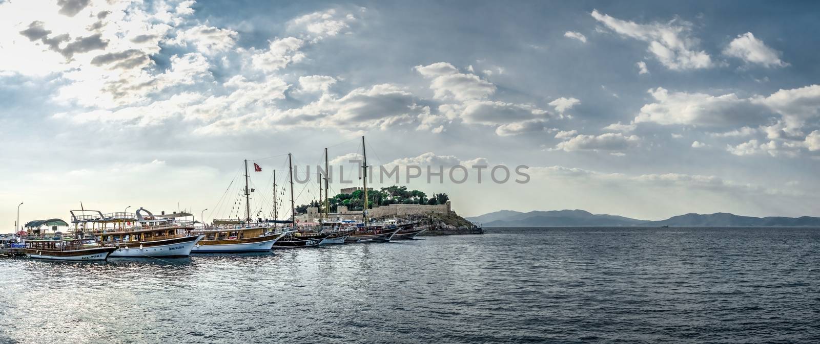 Kusadasi, Turkey – 07.18.2019. Pleasure boat parking near Kusadasi castle in Turkey on a summer evening