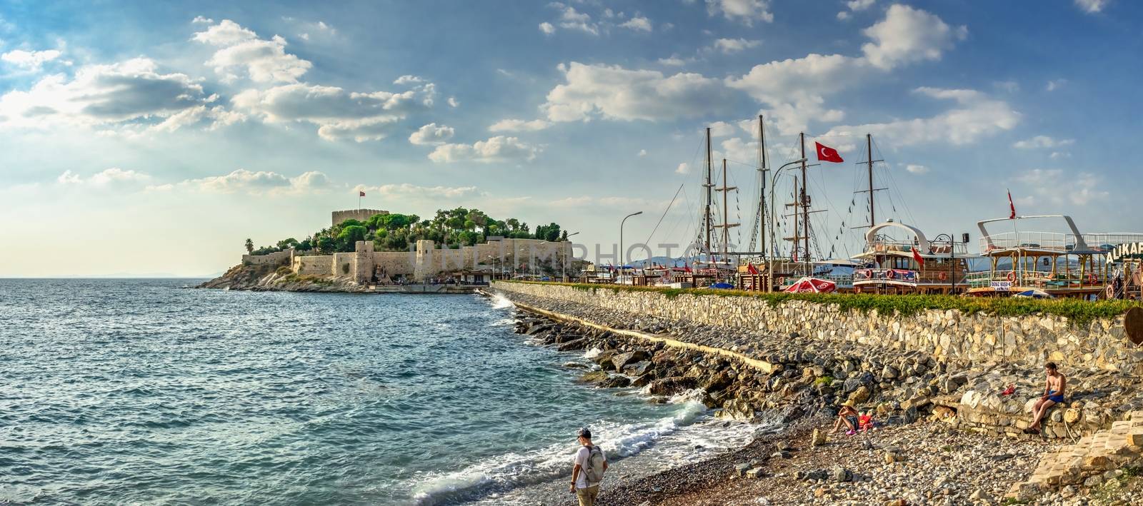 Kusadasi, Turkey – 07.18.2019. Pleasure boat parking near Kusadasi castle in Turkey on a summer evening