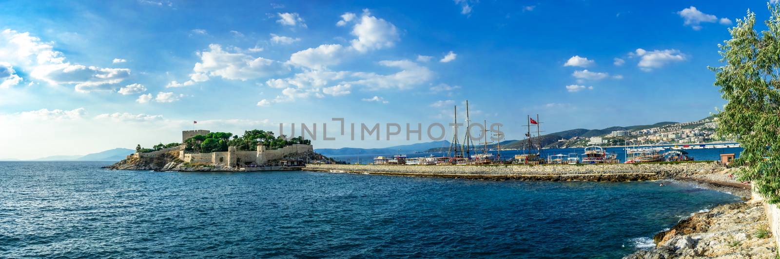 Kusadasi, Turkey – 07.18.2019.  Kusadasi castle in Turkey and pleasure boat parking on a summer evening