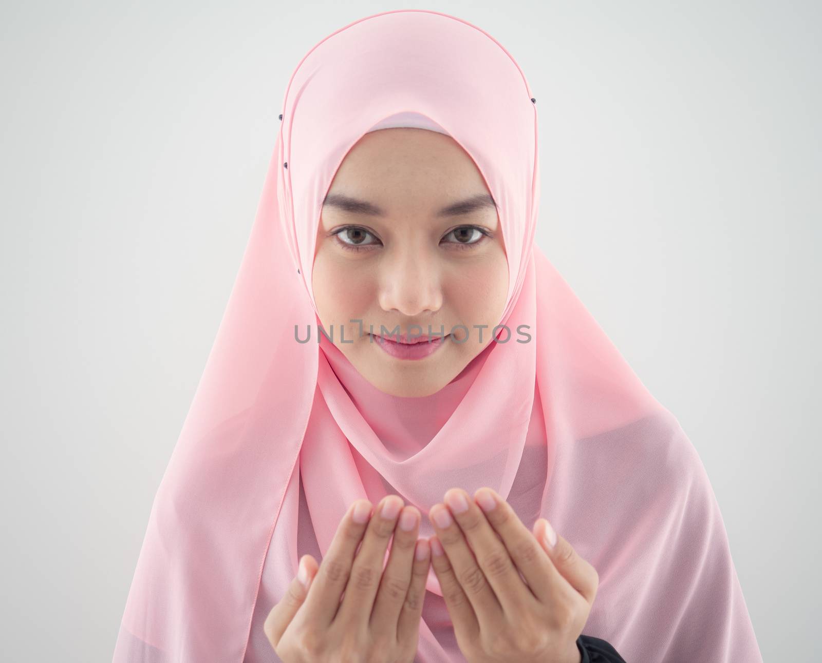 Close up Portrait of a beautiful Muslim Asian woman in a pink hijab on white background.