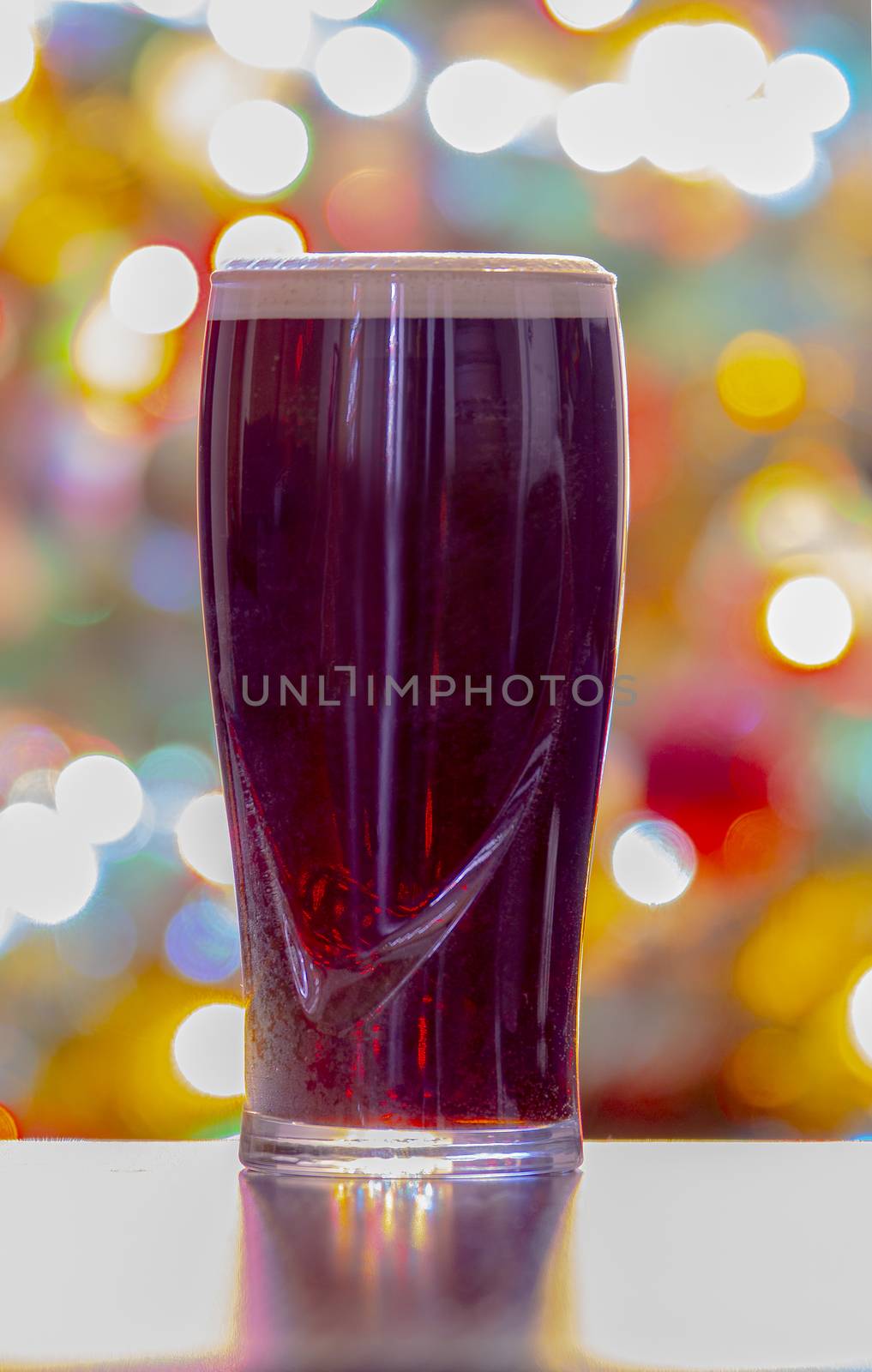 A Stouts Dark Beer with Christmas lights on the background. Guinness dark Irish dry stout. Vertical View by oasisamuel