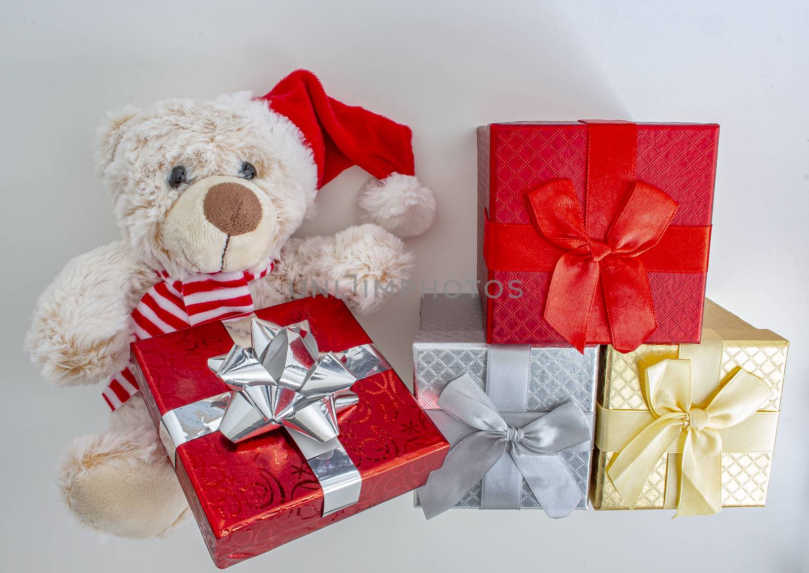 Light brown teddy bear with a santa hat and present boxes