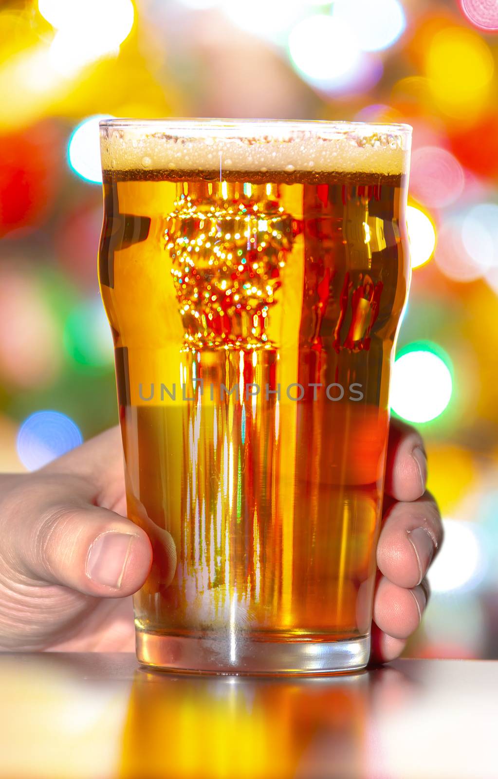 A Beer pint and glass with Christmas lights on the background by oasisamuel