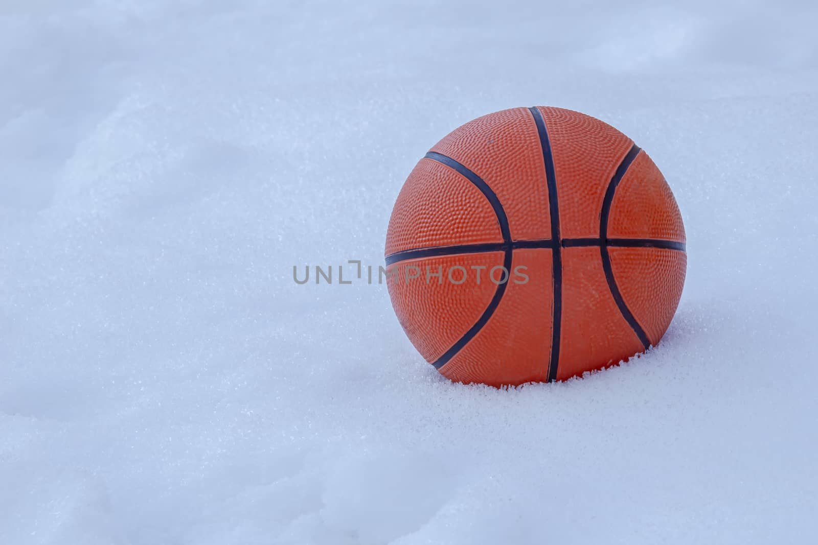 Basket ball on snow during winter by oasisamuel