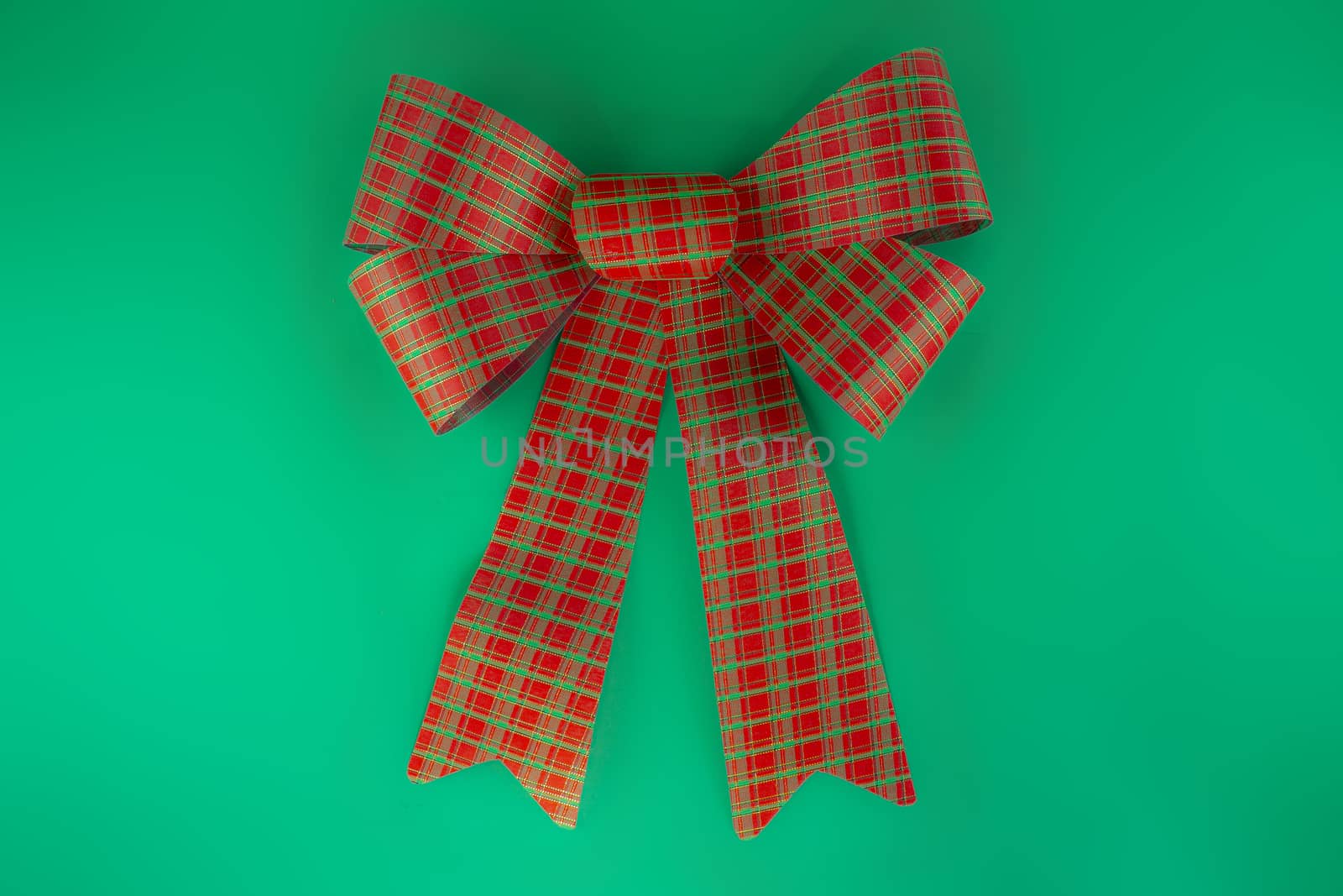 Red bow isolated on green background by oasisamuel