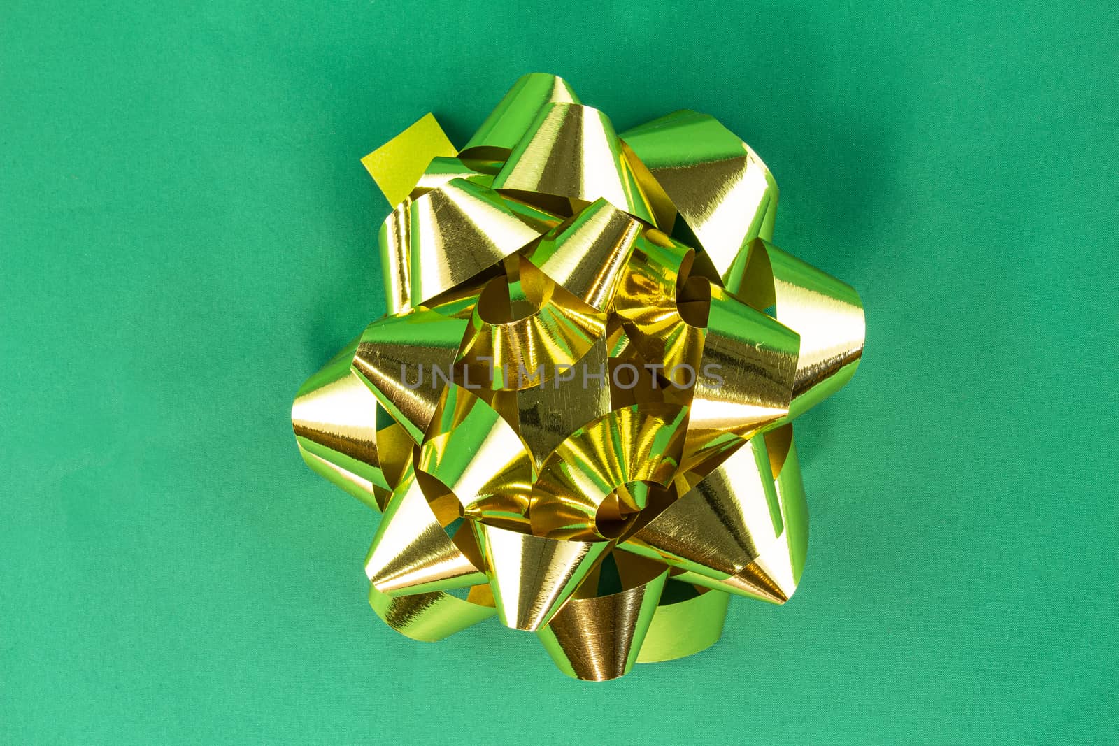 Golden bow on green background
