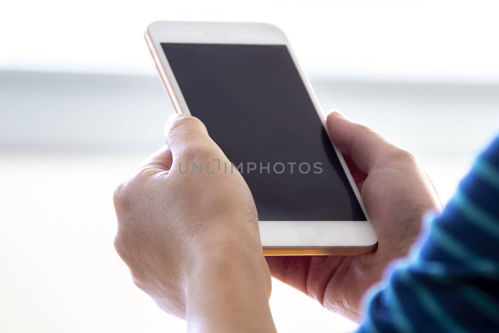 Woman holds a smart phone on her hands.