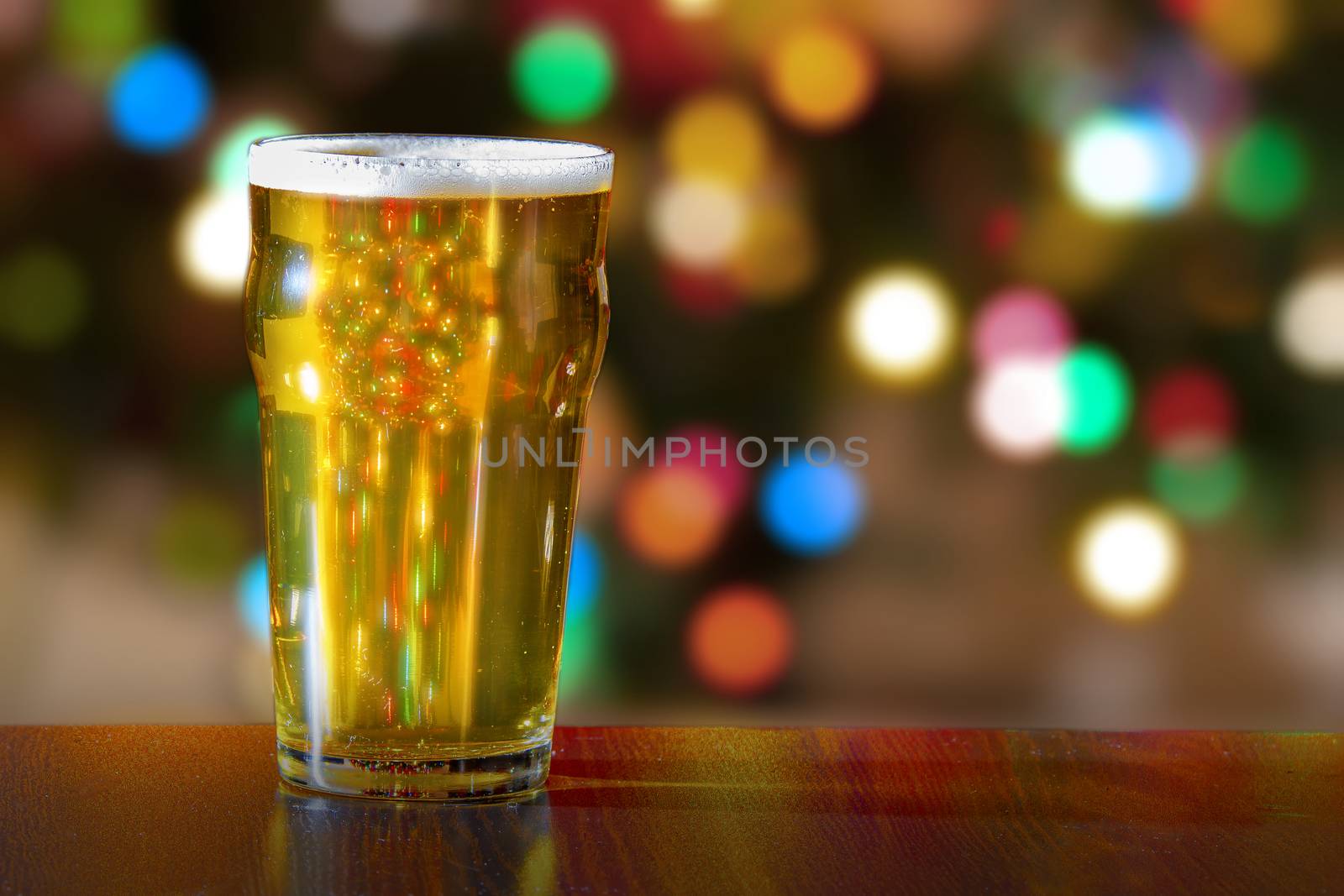 Pint of beer with christmas tress lights on the background by oasisamuel