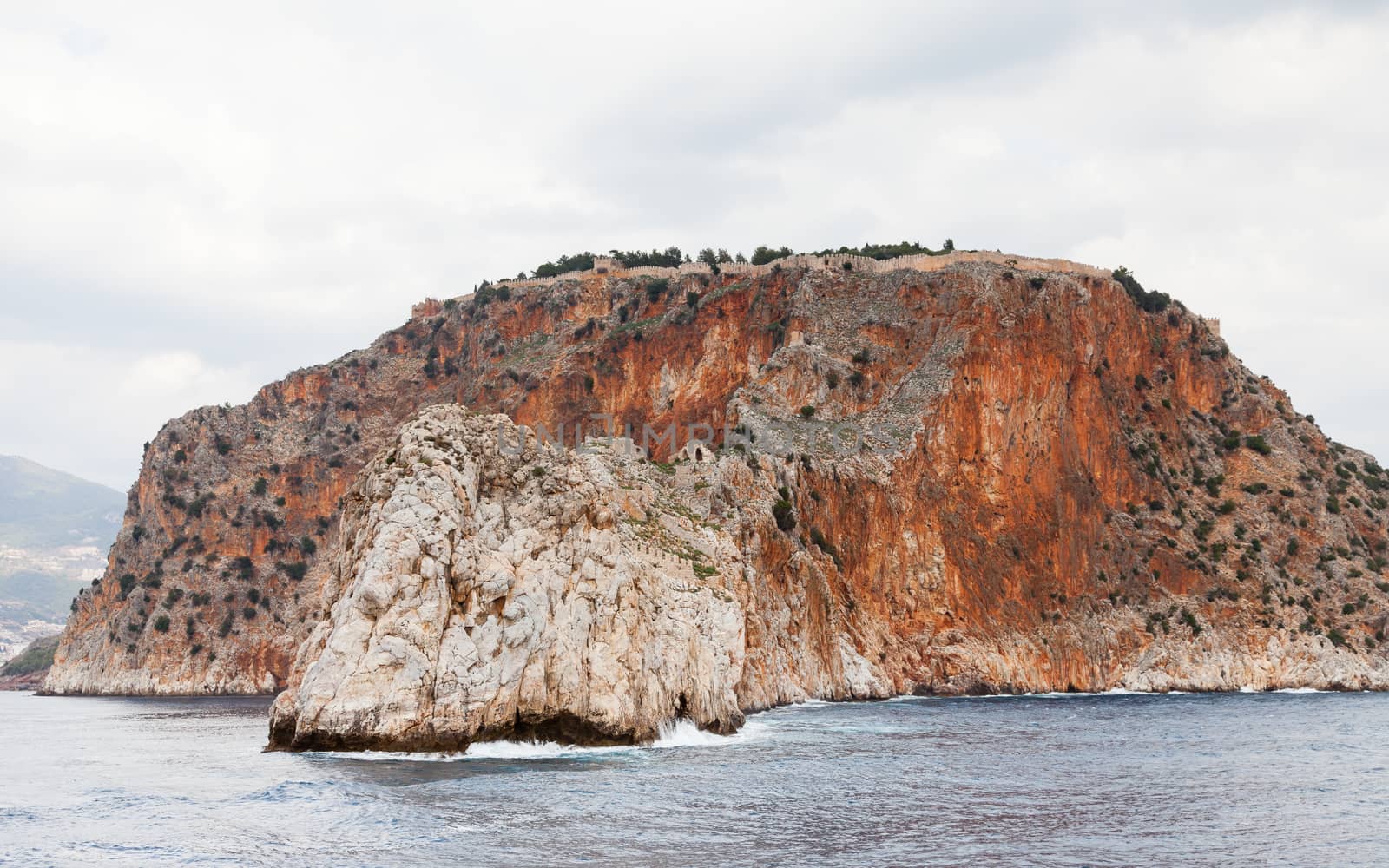 The fortified walls of Alanya Castle in Southern Turkey as viewed from the Mediterranean Sea.  The castle is located on a rocky peninsula and dates back to the 13th century.