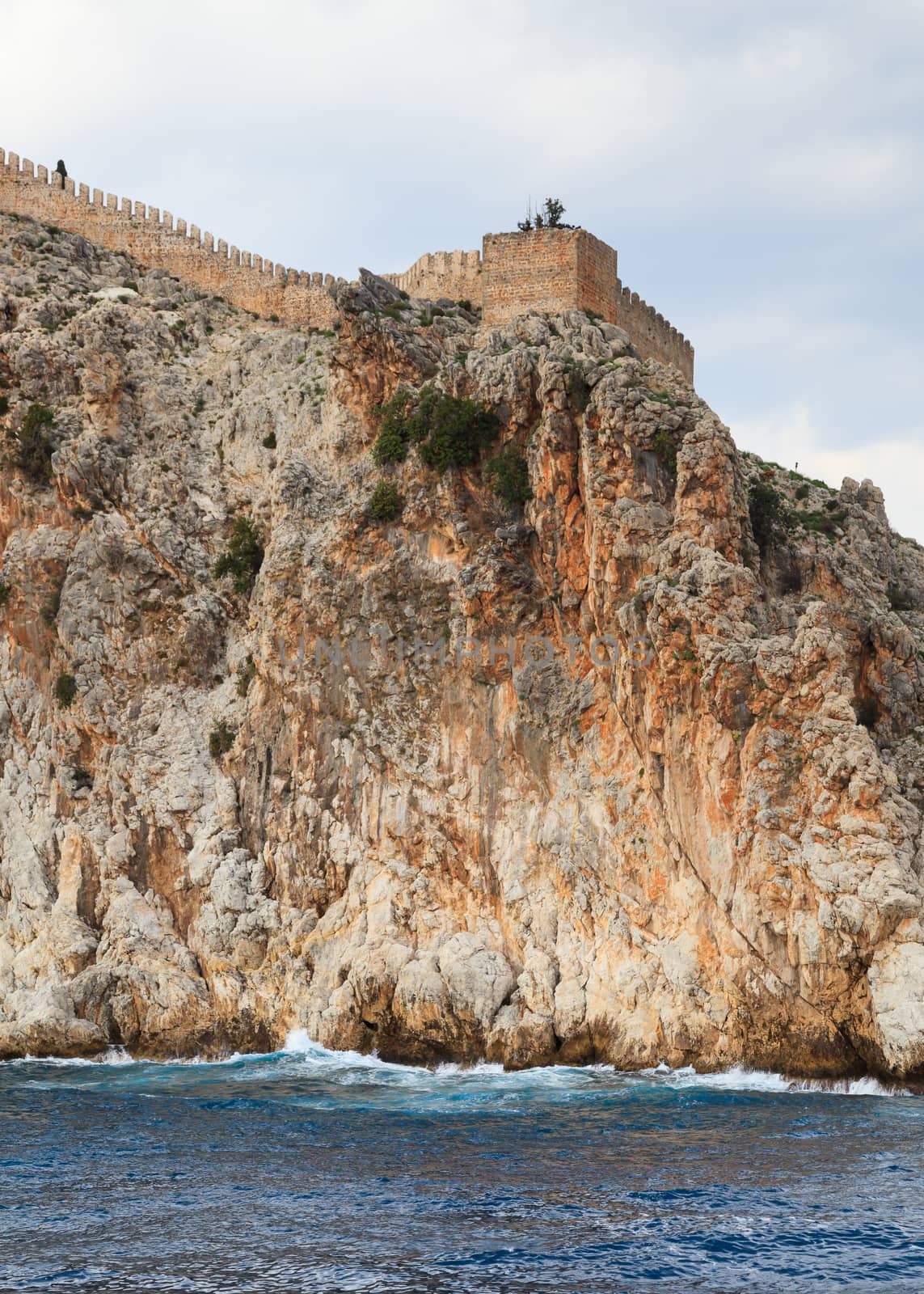 The fortified walls of Alanya Castle in Southern Turkey as viewed from the Mediterranean Sea.  The castle is located on a rocky peninsula and dates back to the 13th century.