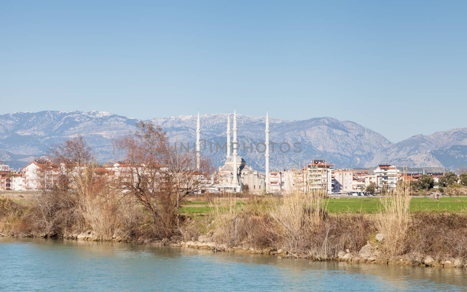 The view looking across Manavgat River towards the town of Manavgat in the province of Antalya, southern Turkey.  Kulliye mosque, with its four minarets dominates the skyline.