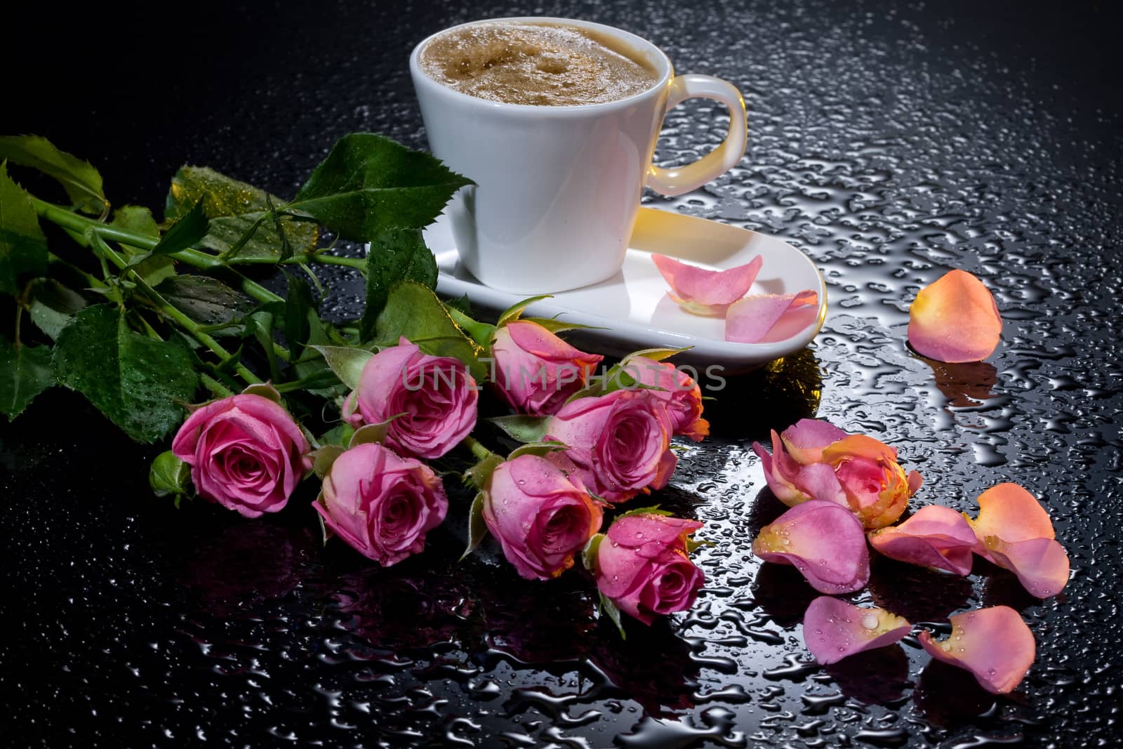 Three red roses on a black background with water drops