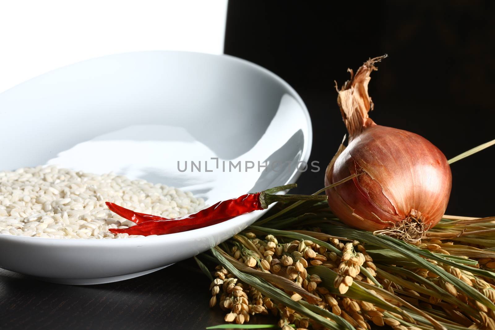 Extreme close up of onions, rice and chilli. Healthy organic raw food ready for cooking on a white and black background