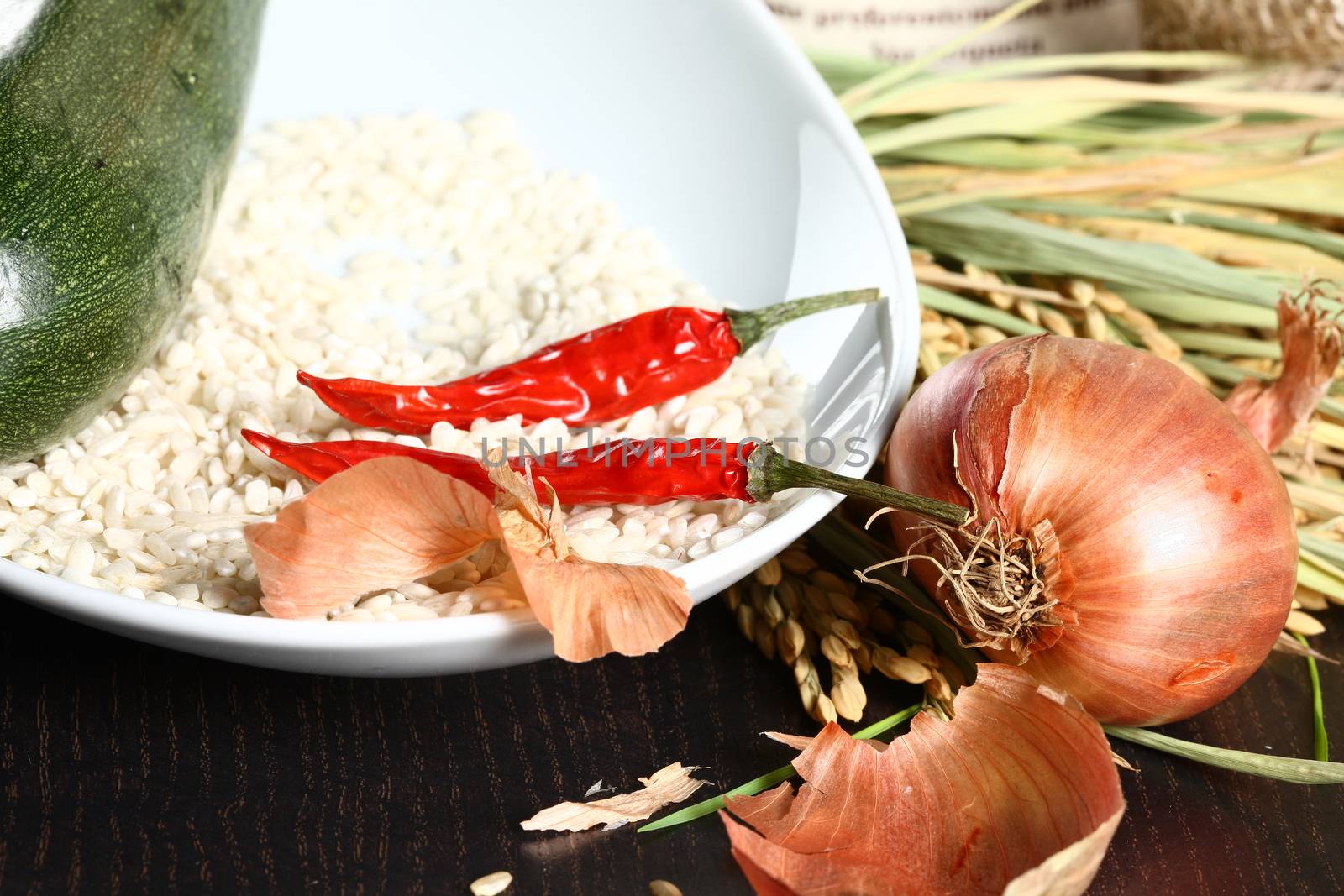 Healthy organic raw food ready for cooking. Close up of onion peel with rice corn laying on a table and rice plant