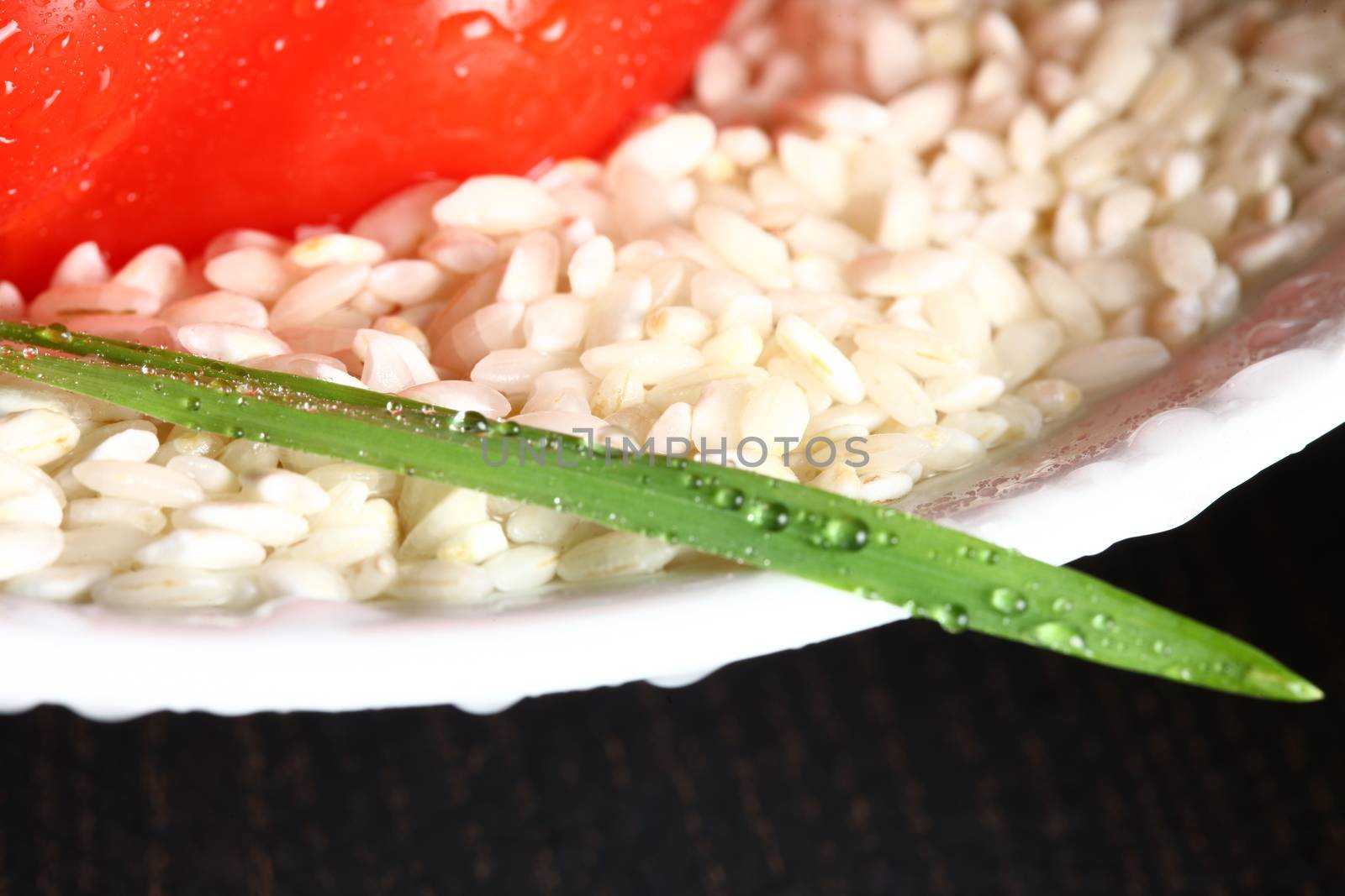 Healthy fresh organic food with water drops with rice and red pepperoni and a green leaf and rice corn