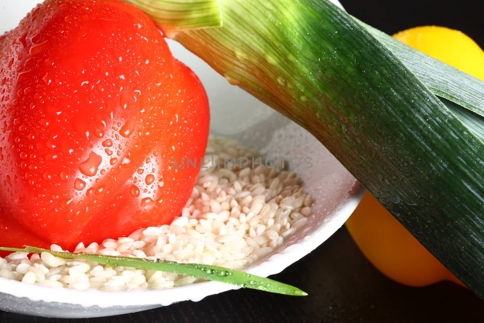 Healthy fresh organic food with water drops with rice and red pepperoni and green leek