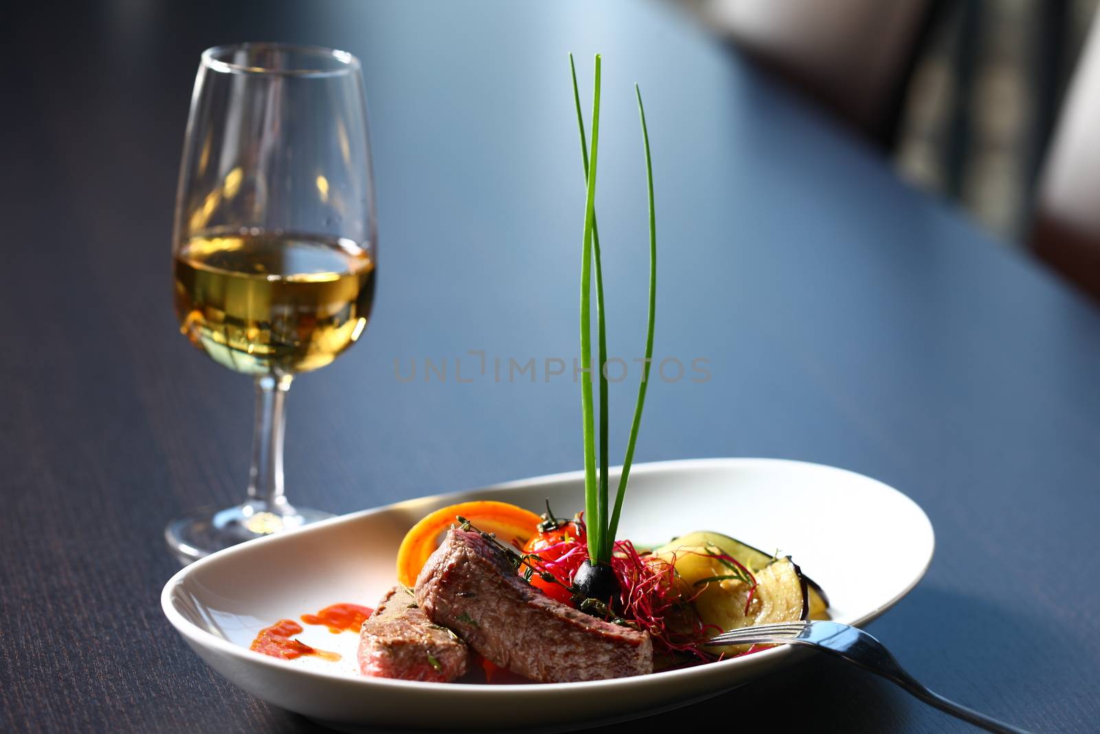 a good meal with wine. close up of a dish with meal, rice and mushrooms and a glass of wine in background . On clean grey table
