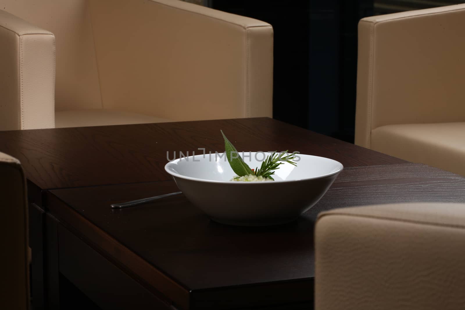 Close up of rice dish - asian food on a small dark wood table with chairs in background - rice dish - asian food