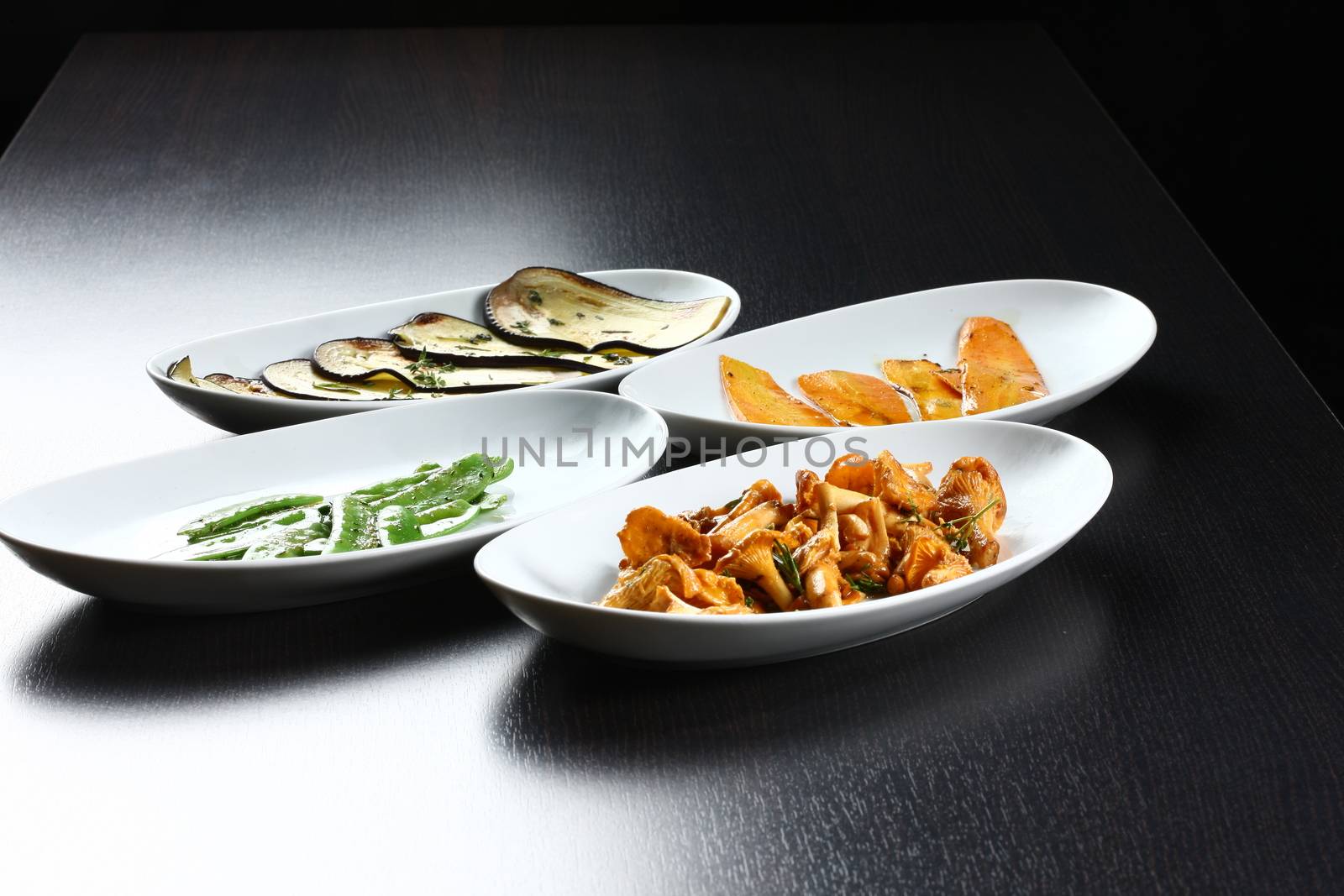 Cooked food plates on table top, ready to served for guests in a dark setting. Mushrooms and leek cooked