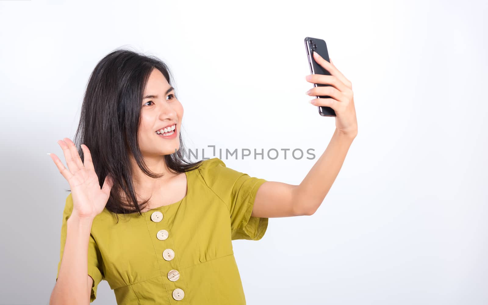 Portrait Asian beautiful happy young woman standing smile, holding mobile phone her taking selfie on white background, with copy space