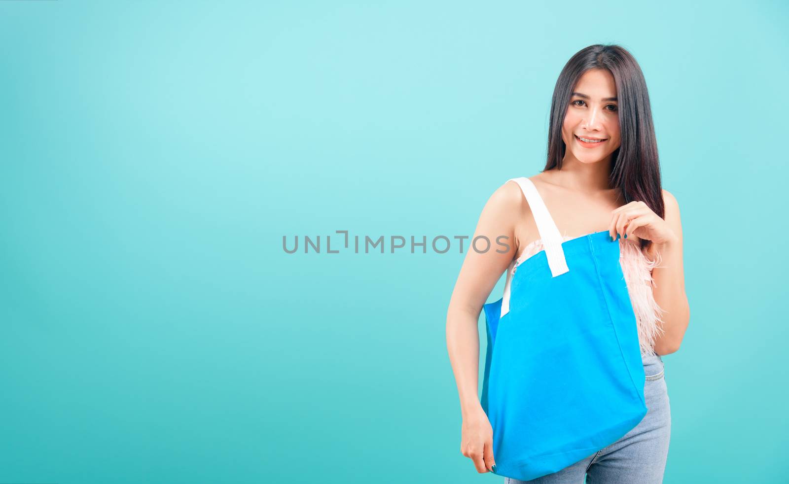 Smiling face portrait asian beautiful woman holding eco blue fab by Sorapop