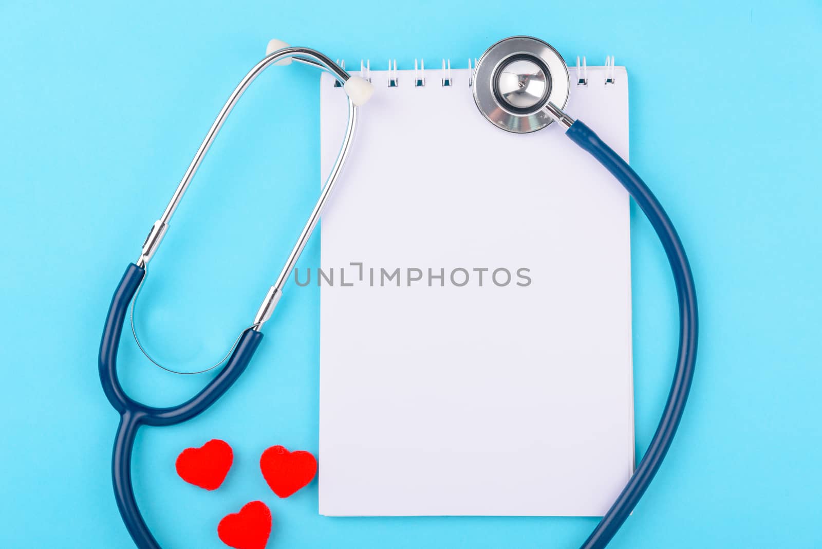 Doctor's Day concept, flat lay top view, stethoscope with peper note diagnosis of heart disease on blue background with copy space for text