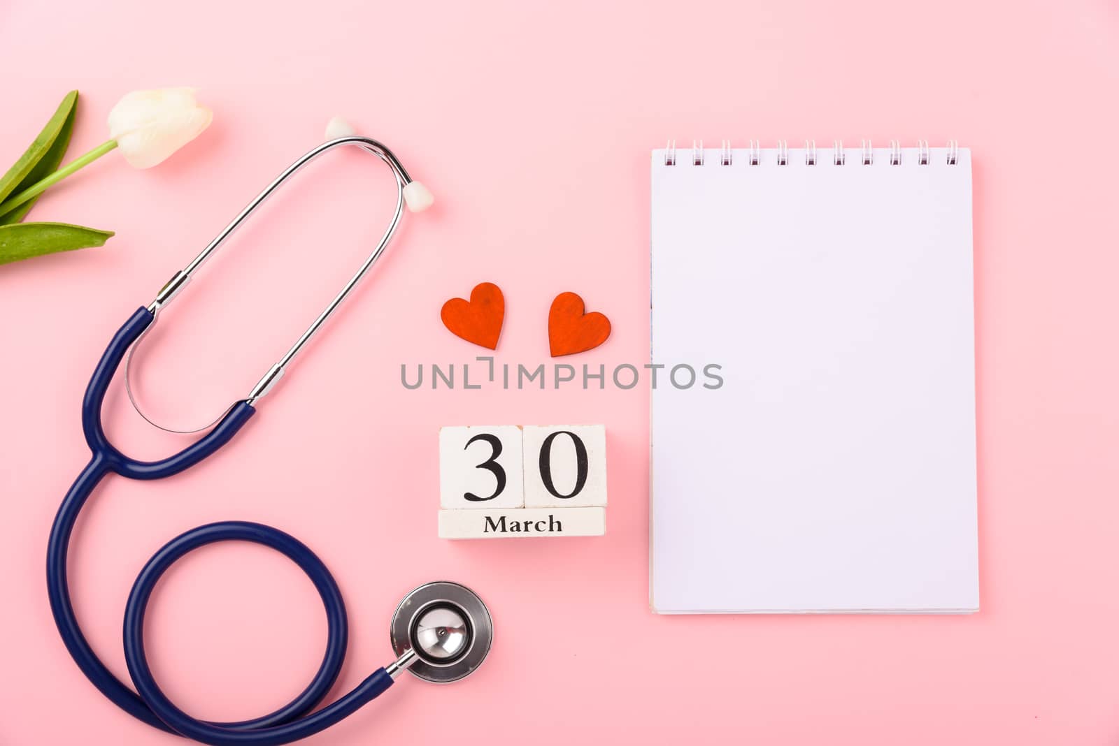 Doctor's Day concept, flat lay top view, equipment medical red heart stethoscope and note book on pink background, care patient in hospital with copy space for text