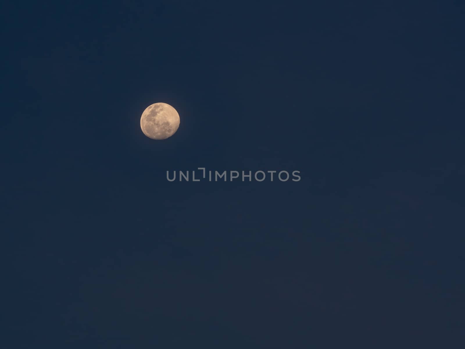 The lonely full moon on dark blue sky in evening.