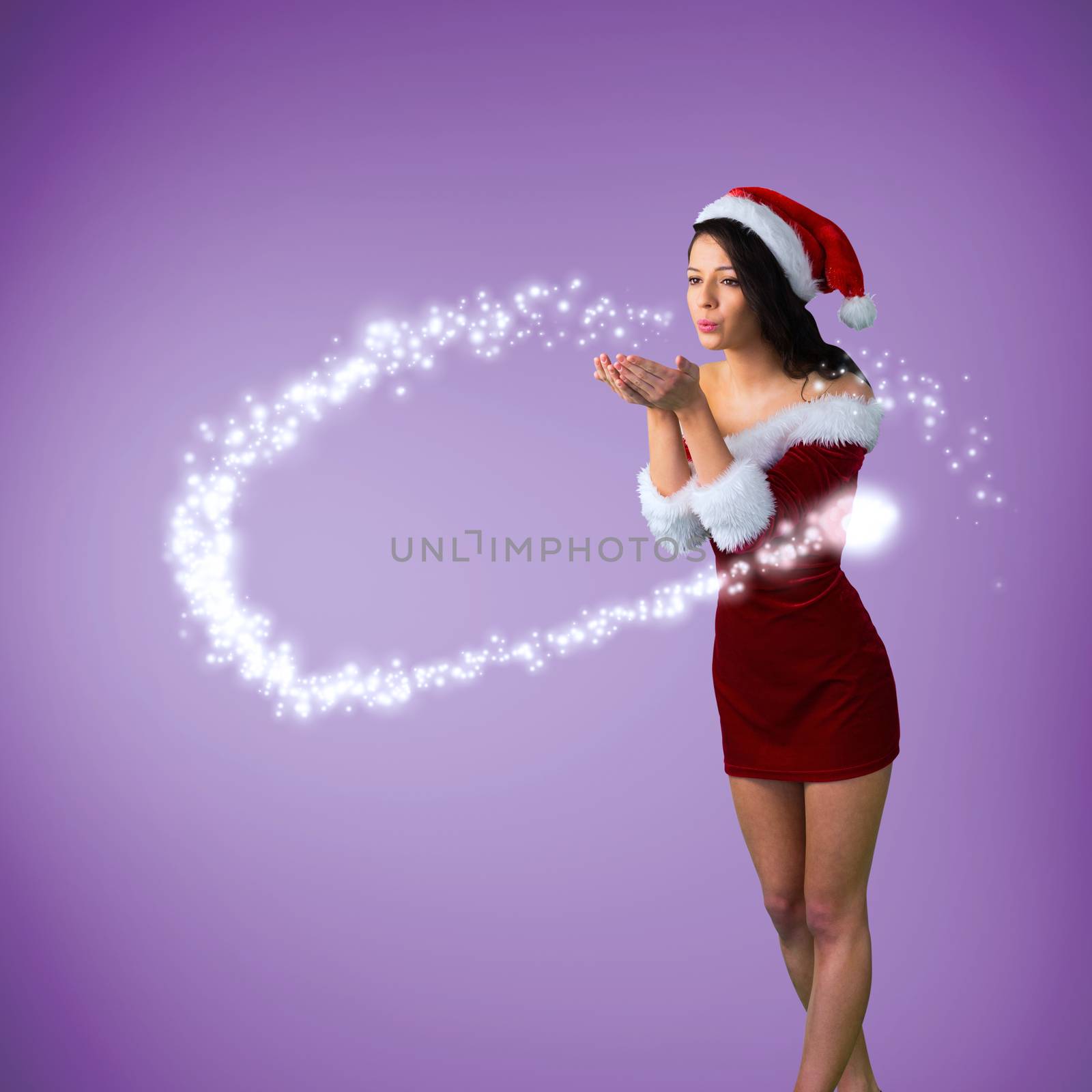Pretty girl in santa outfit blowing against purple vignette