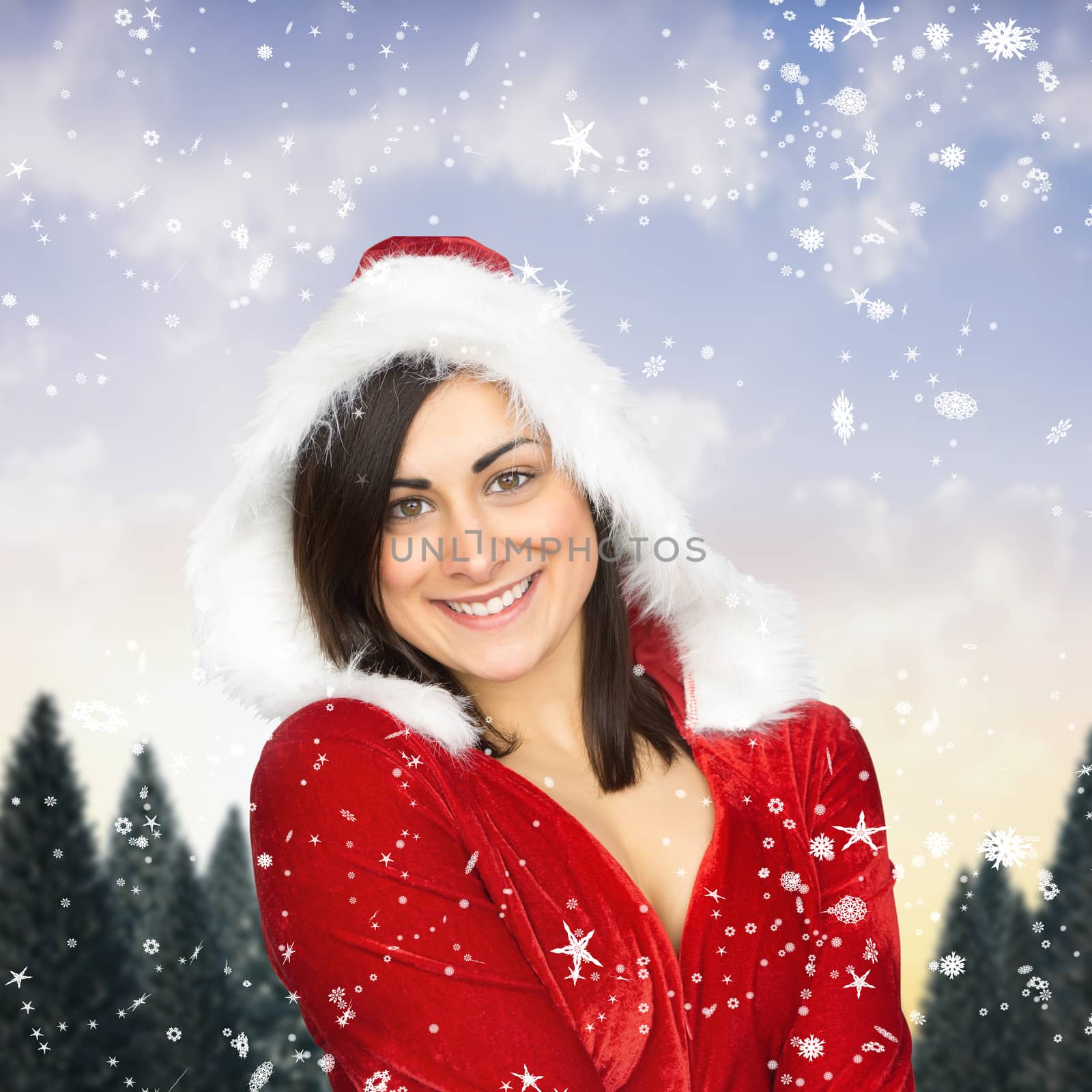Pretty girl smiling in santa outfit against snowy landscape with fir trees