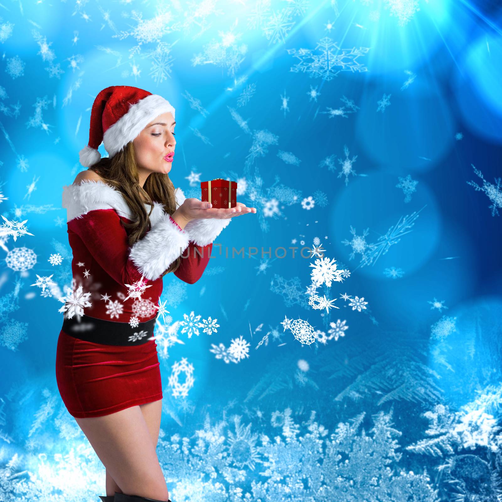 Pretty girl in santa costume holding hand out against blue snow flake pattern design