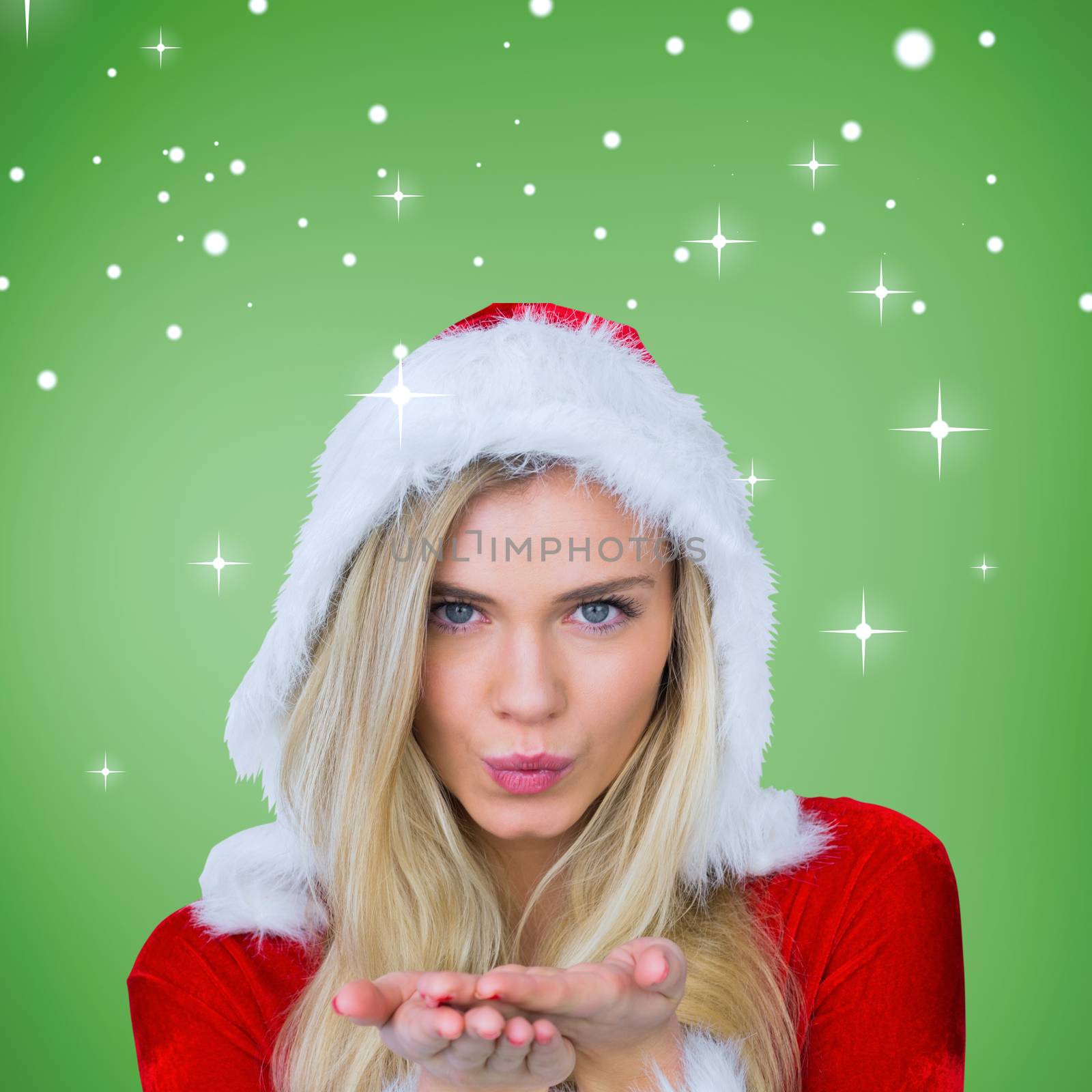 Pretty girl in santa outfit blowing against green vignette