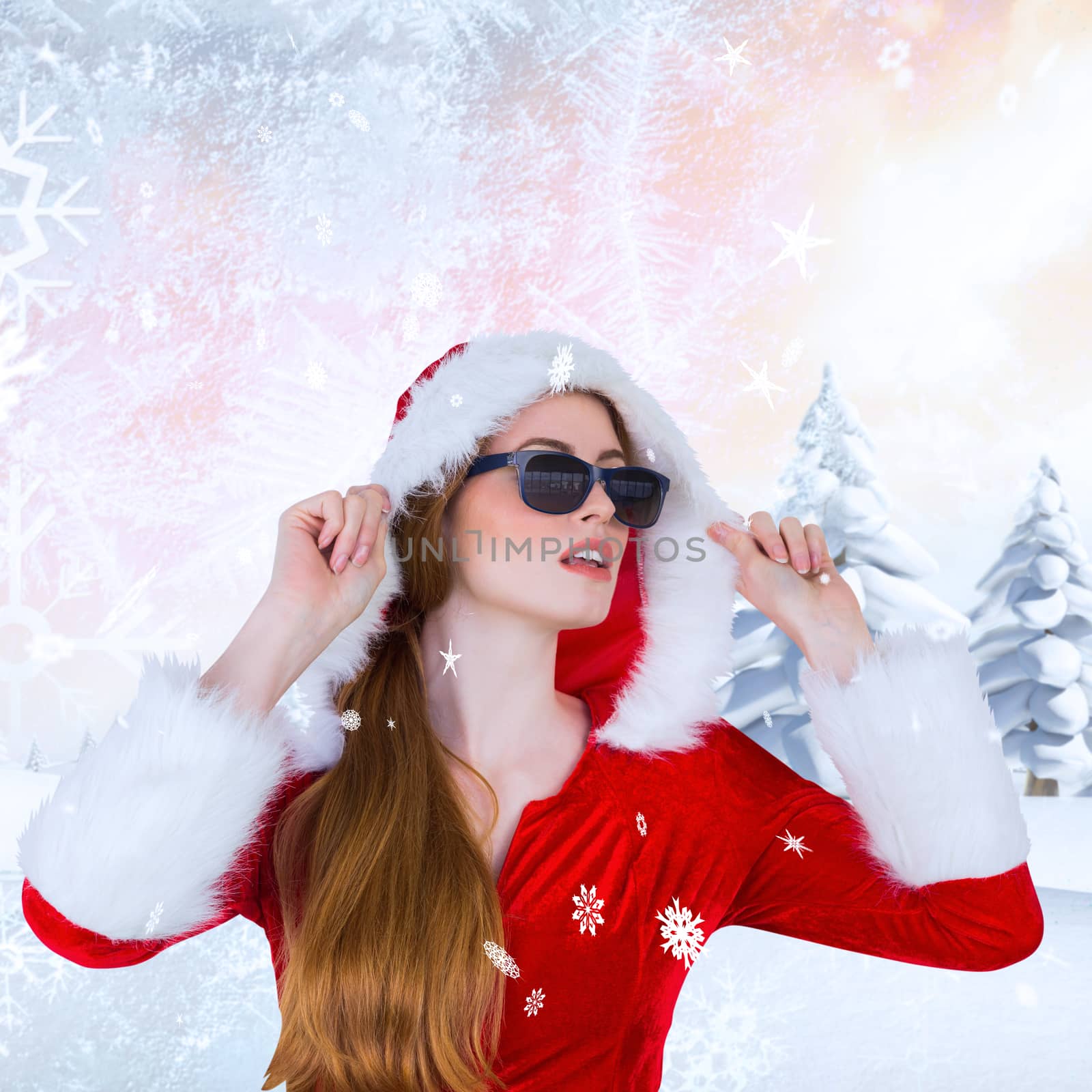 Cool santa girl wearing sunglasses against snowy landscape with fir trees