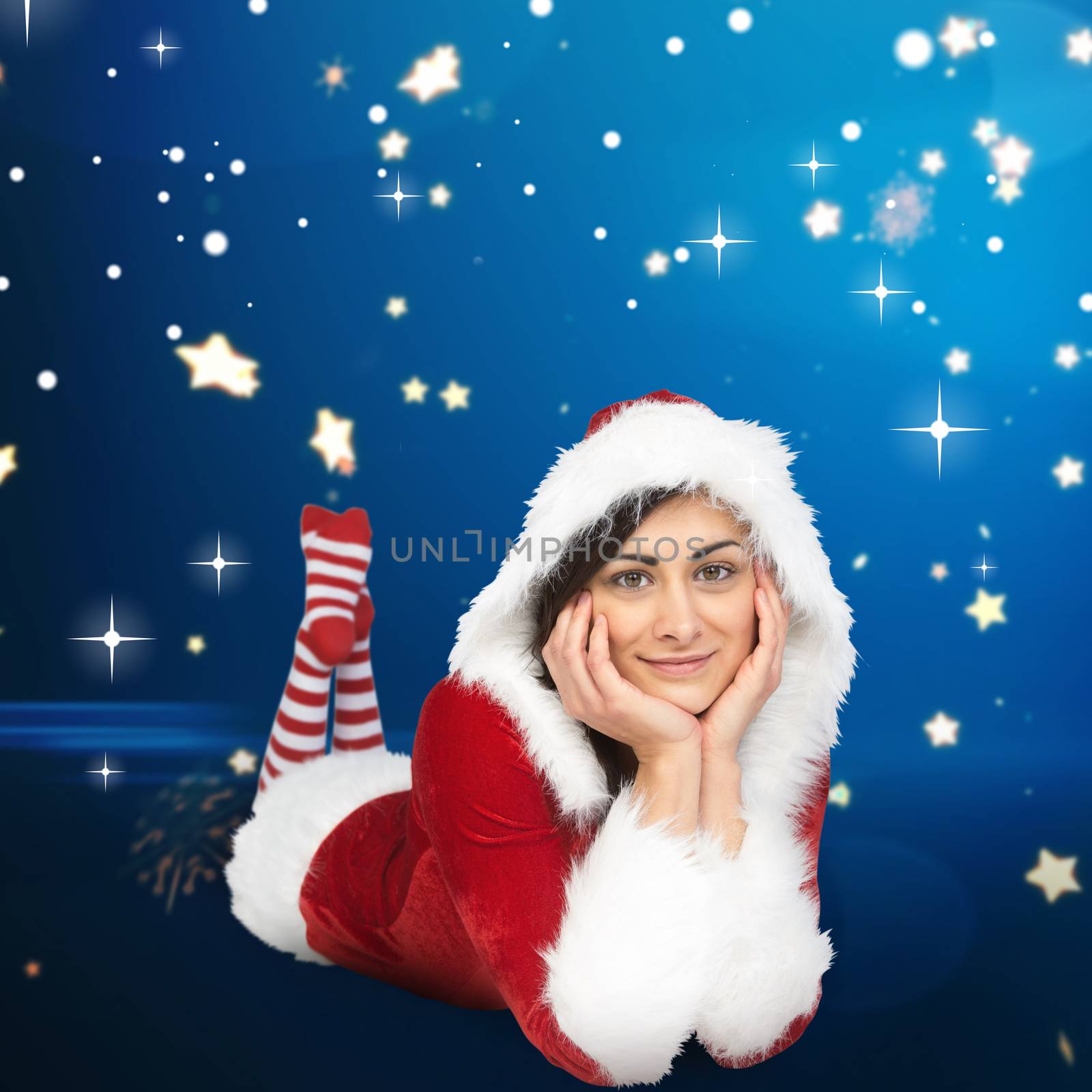 Pretty girl smiling in santa outfit against bright star pattern on blue