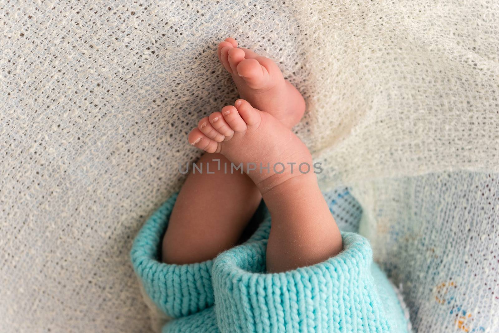 Closeup of a newborn baby feet with beautiful selective focus. Concept for maternity and tenderness