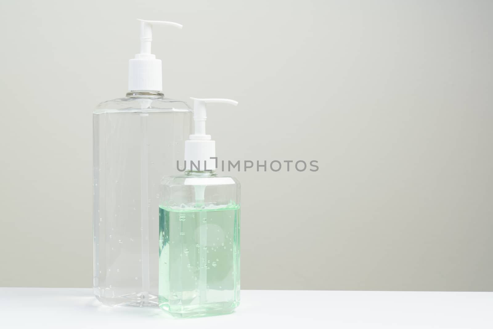 Two hand sanitizer in plastic bottle on white background by Kenishirotie