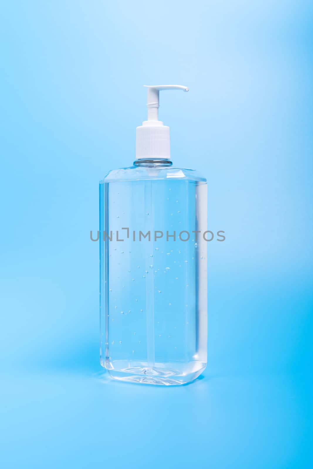 Hand sanitizer in plastic bottle on blue background by Kenishirotie