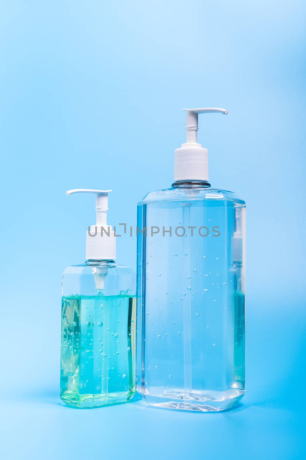 Two hand sanitizer in plastic bottle isolated on blue background
