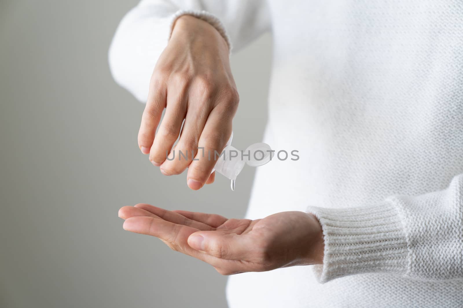 Female hands using hand sanitizer isolated white background