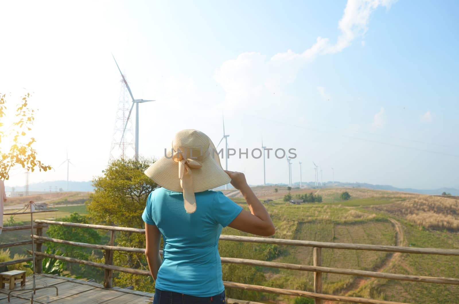 Asian girl looking at windmills on mountain in  blue sky background  at Khao kho in Petchabun province, Thailand.