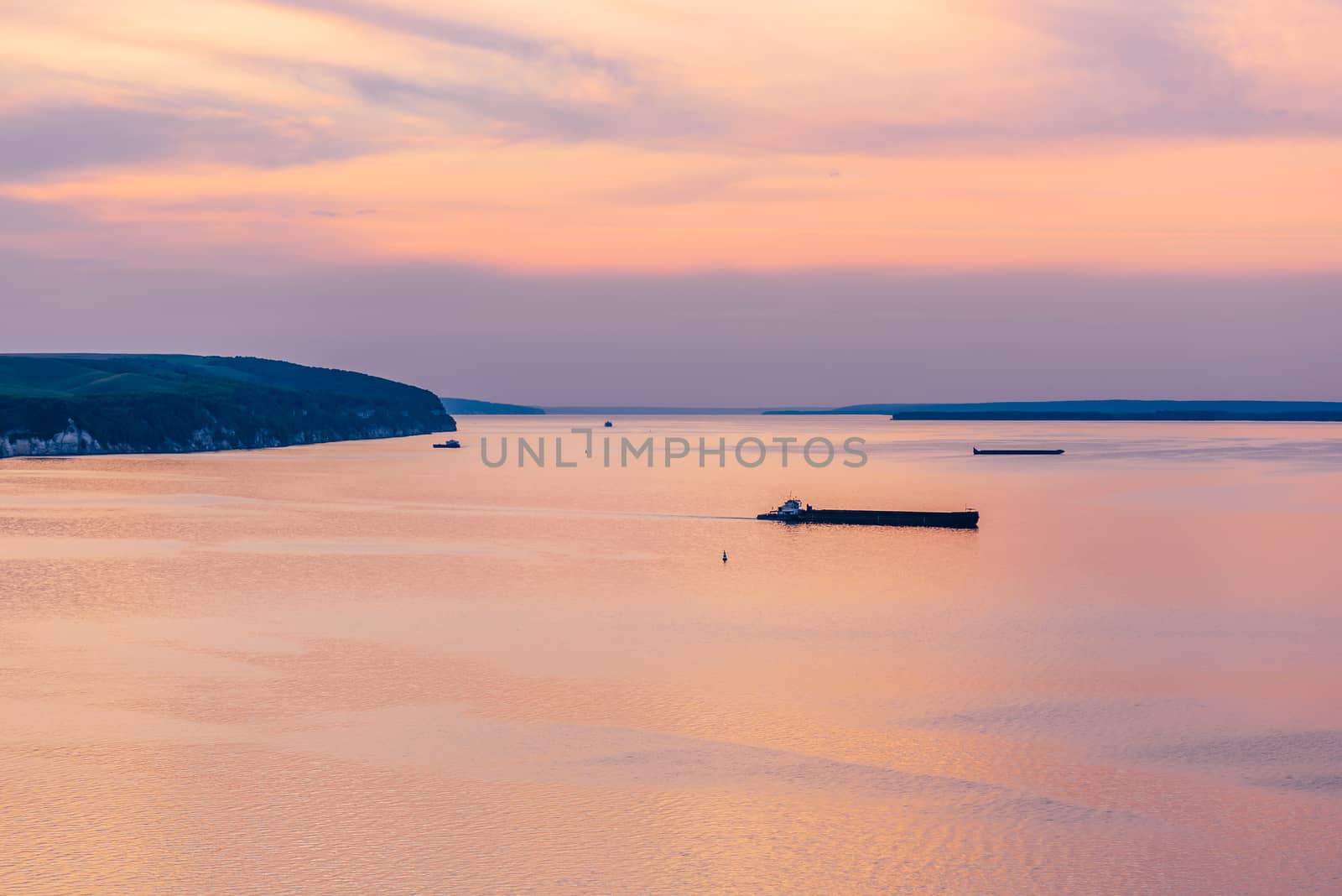 Sunset on navigable river with reflected sky