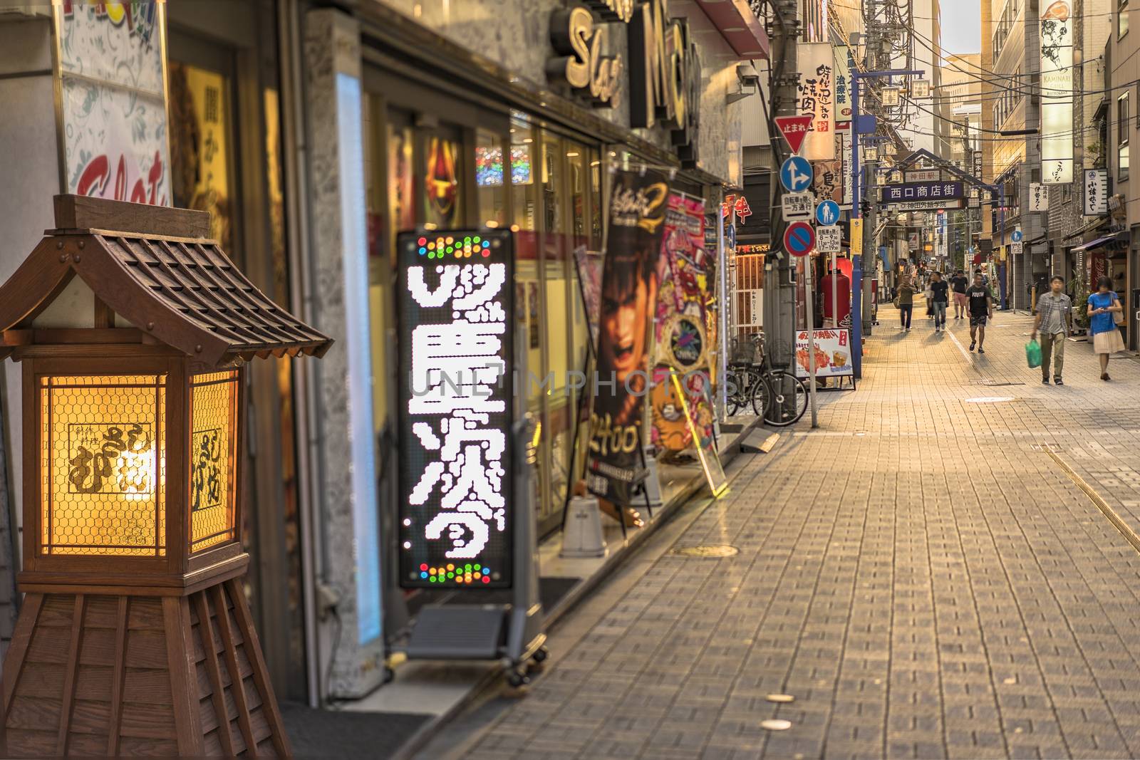 Traditional wooden lantern and blue metal entrance gate of the shopping street from the west exit of Kanda Station on the Yamanote Line. The street extends over 300 meters and has no less than 100 shops, restaurants or pachinko.