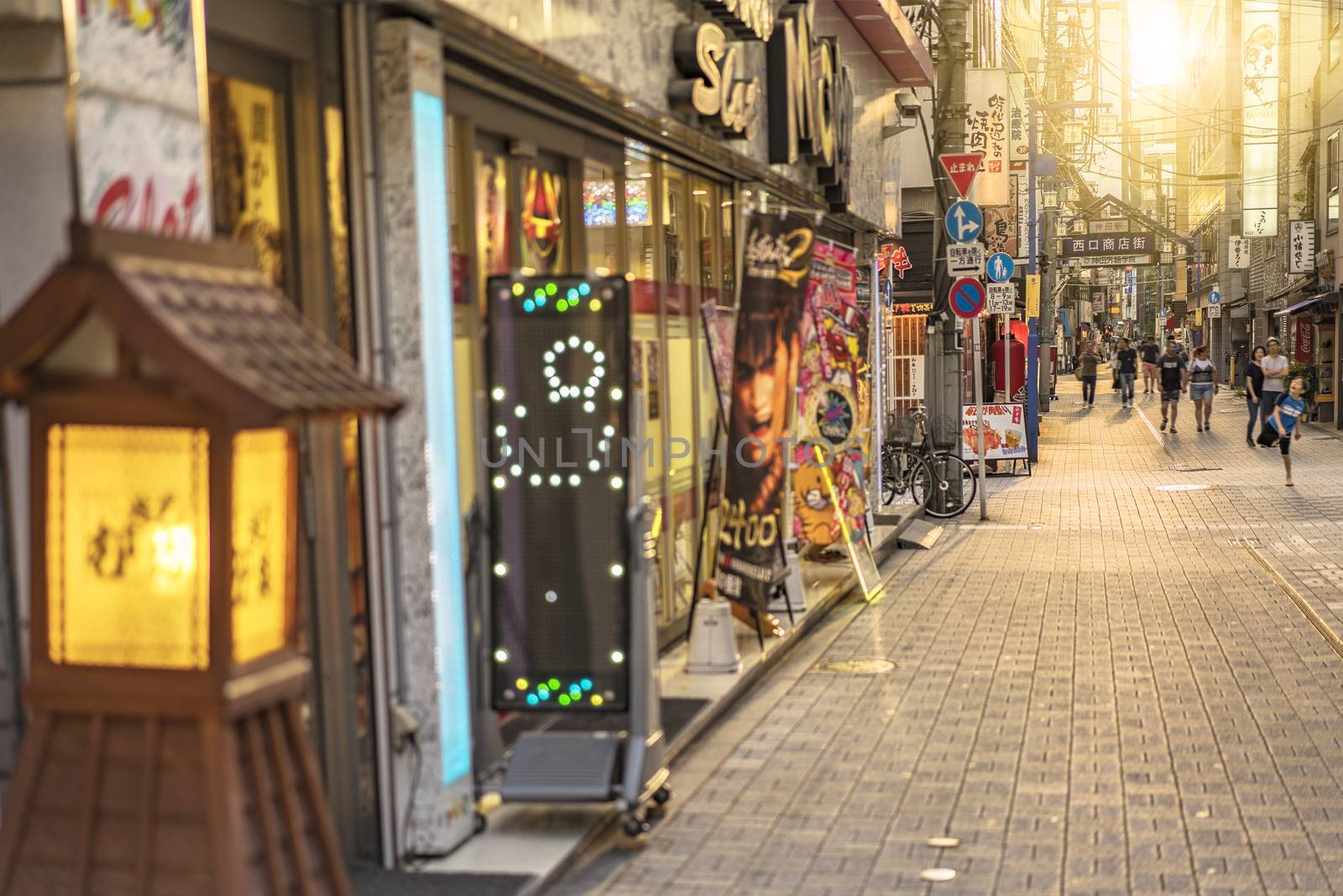 Traditional wooden lantern and blue metal entrance gate of the shopping street from the west exit of Kanda Station on the Yamanote Line. The street extends over 300 meters and has no less than 100 shops, restaurants or pachinko.