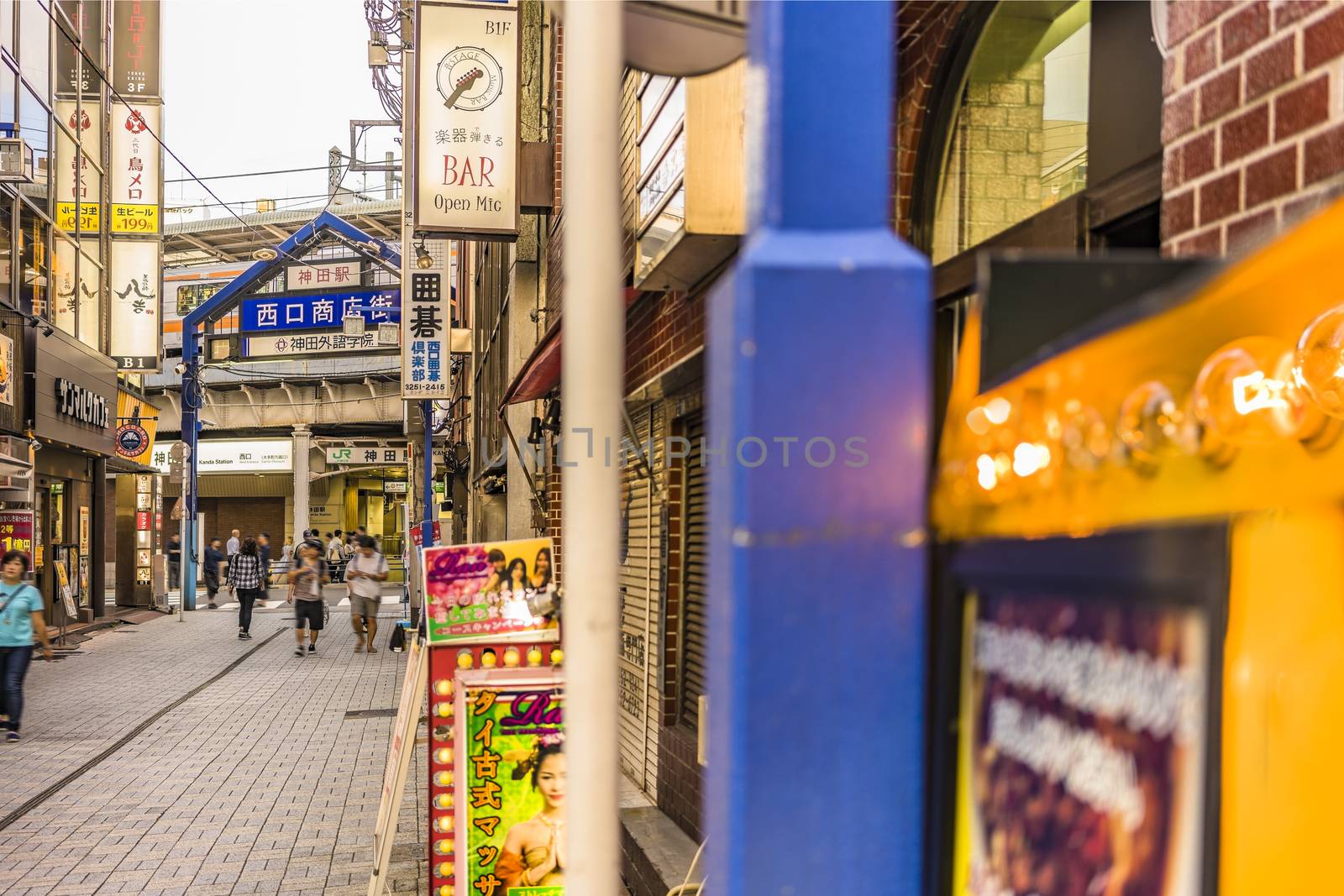 Blue metal entrance gate and neon signs in the shopping street by kuremo