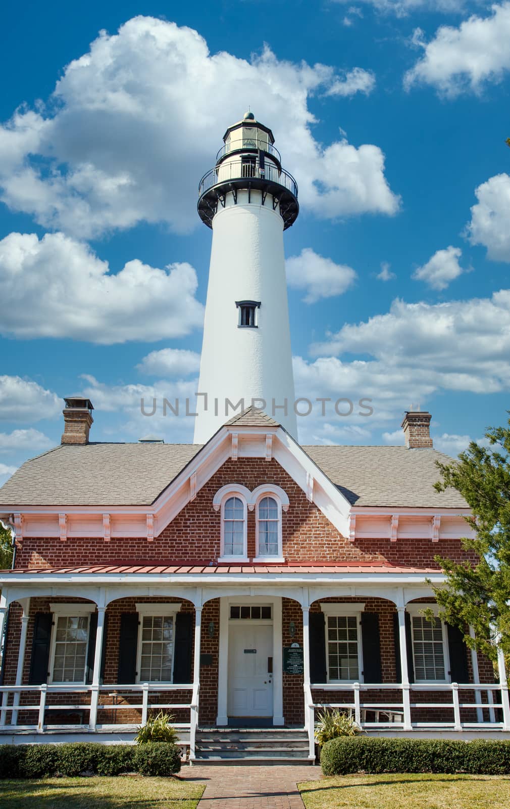 A white lighthouse under clear blue skies