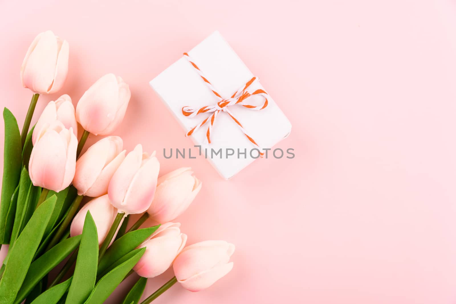 Happy Women's Day, Mother's Day concept. top view flat lay gift box and Tulip flower on pink background, copy space for your text