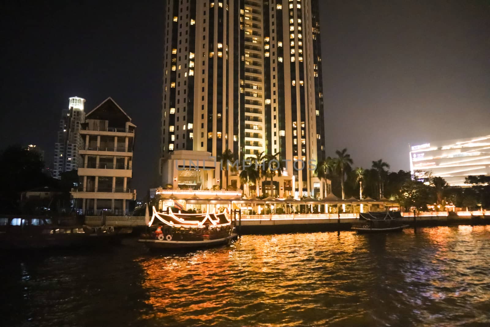 embankment at Chao Phraya River in Bangkok city. With two boats for trip. cityscape in the evening. Nigt life in asia