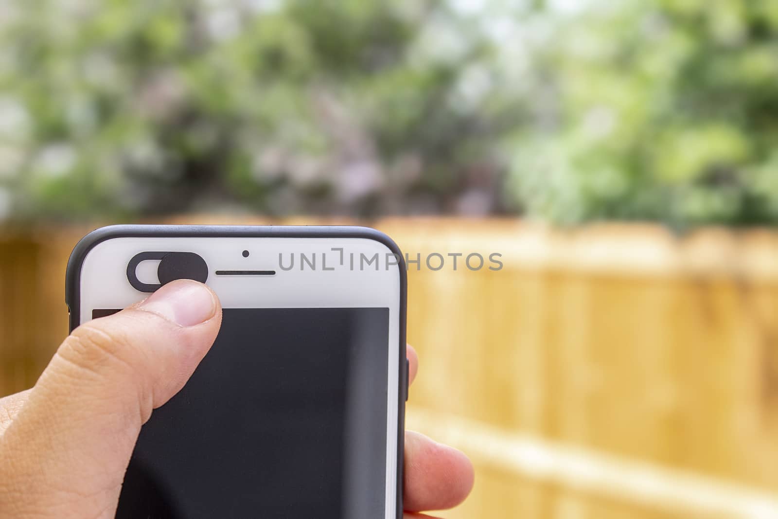 Person holding a mobile phone, sliding a selfie privacy camera cover by oasisamuel