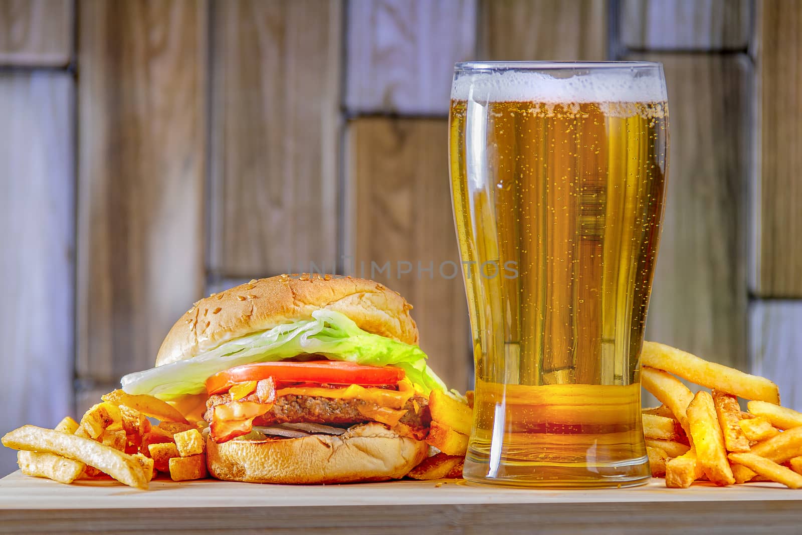 Beer and french fries on a wooden plate