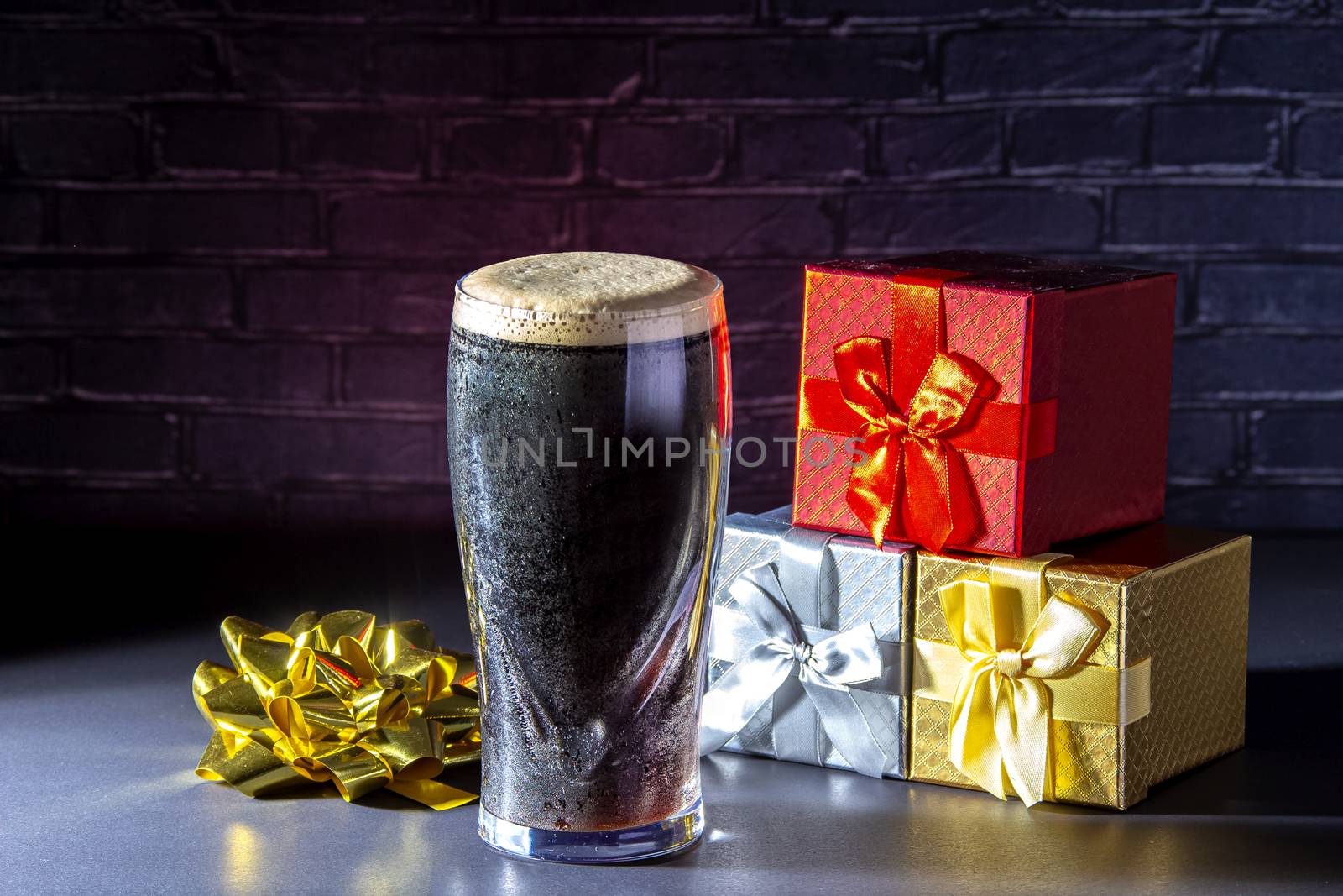 A dark Irish dry stout beer glass with a gift boxes